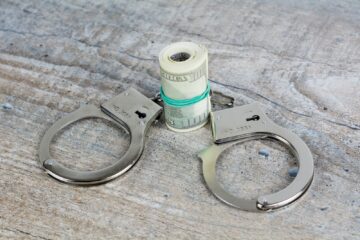 handcuffs and a roll of money on a table